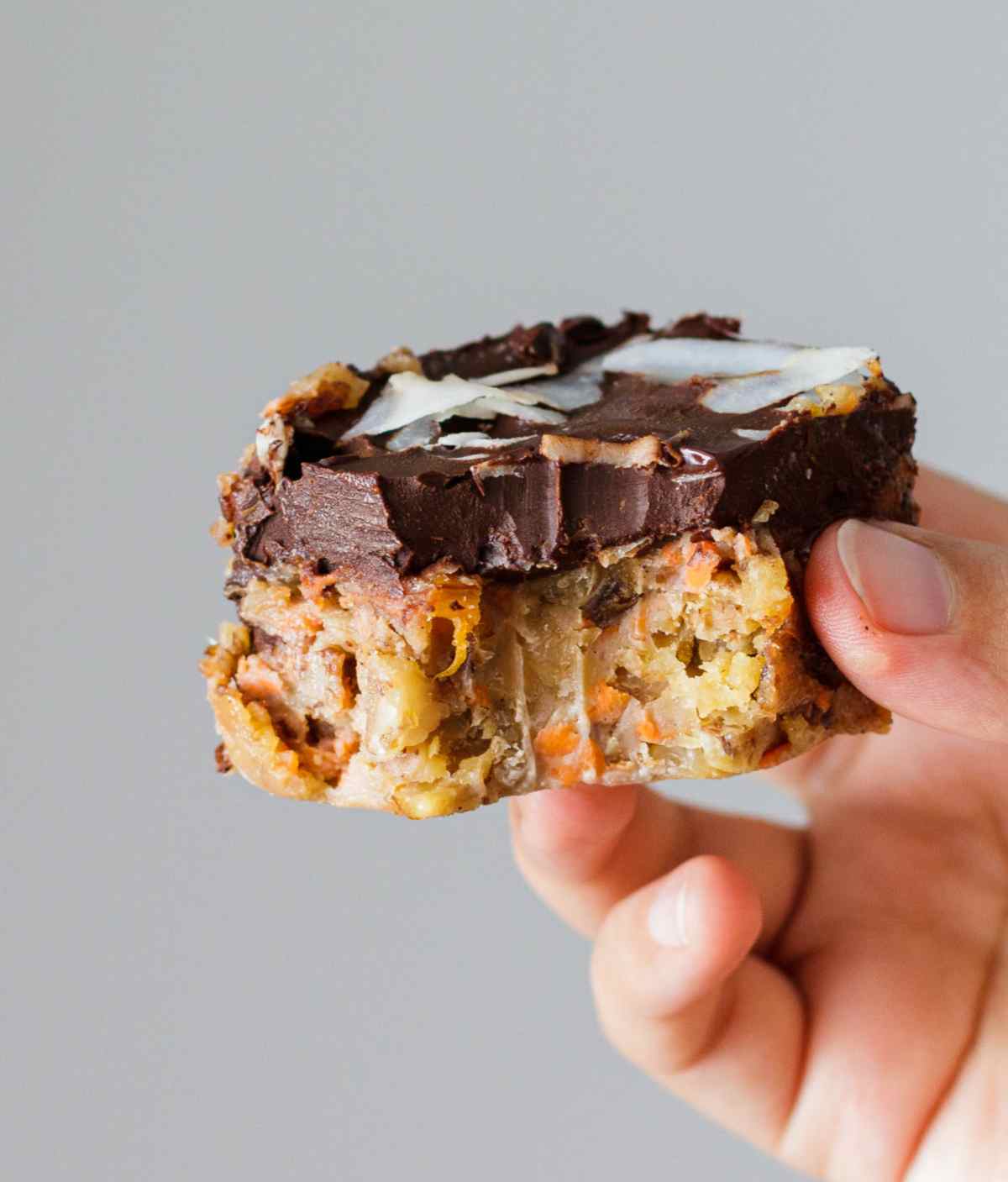 Sugar free and gluten free carrot cake bite held by a hand.