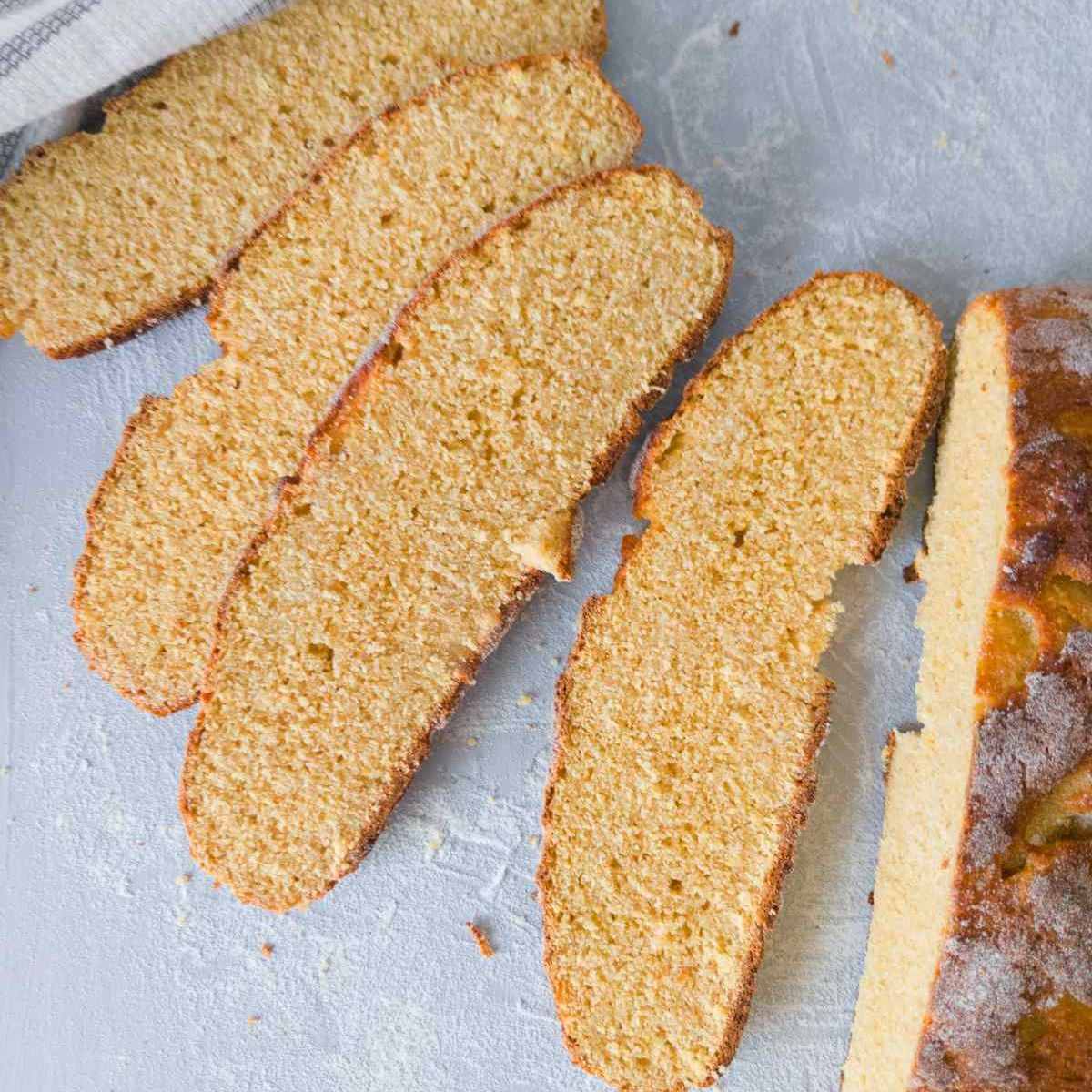 Chickpea bread sliced on a light blue surface.