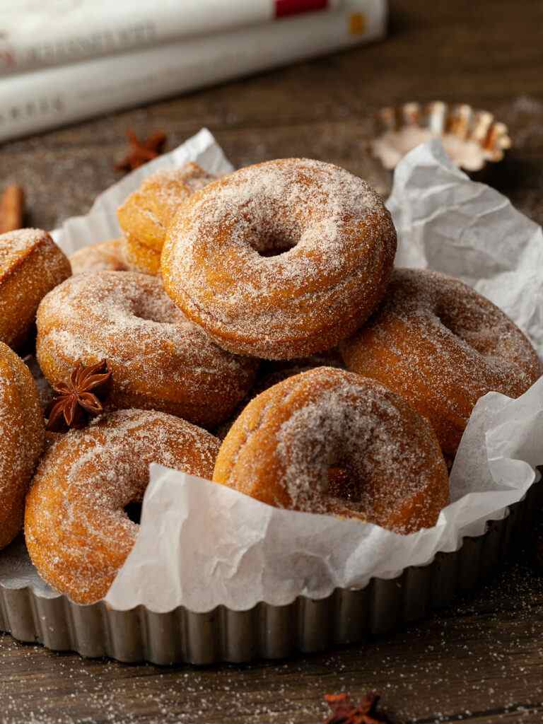 Gluten-free dairy free baked donuts in a bowl with parchment paper.