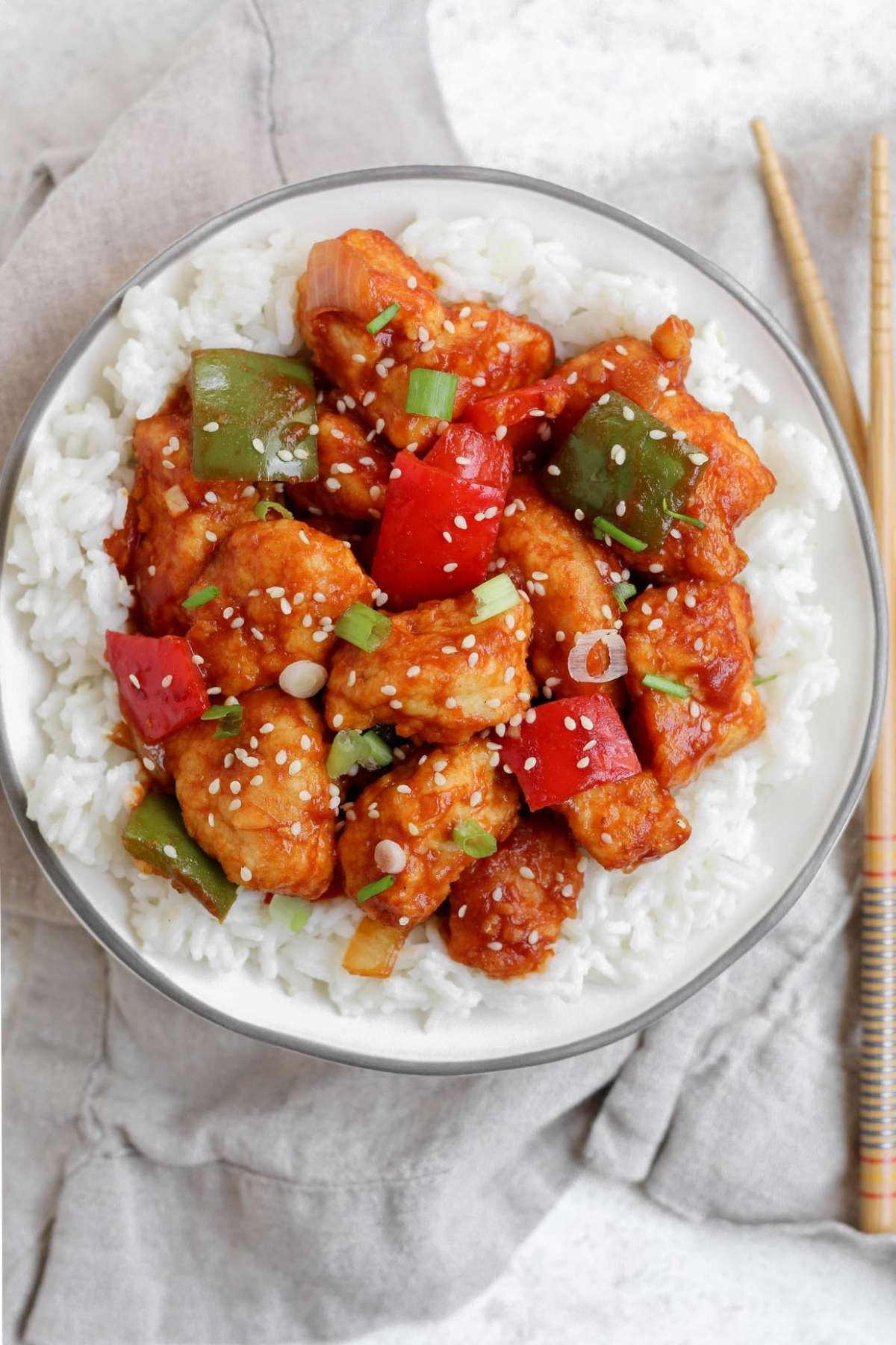 Sweet and sour chicken on a plate with rice.