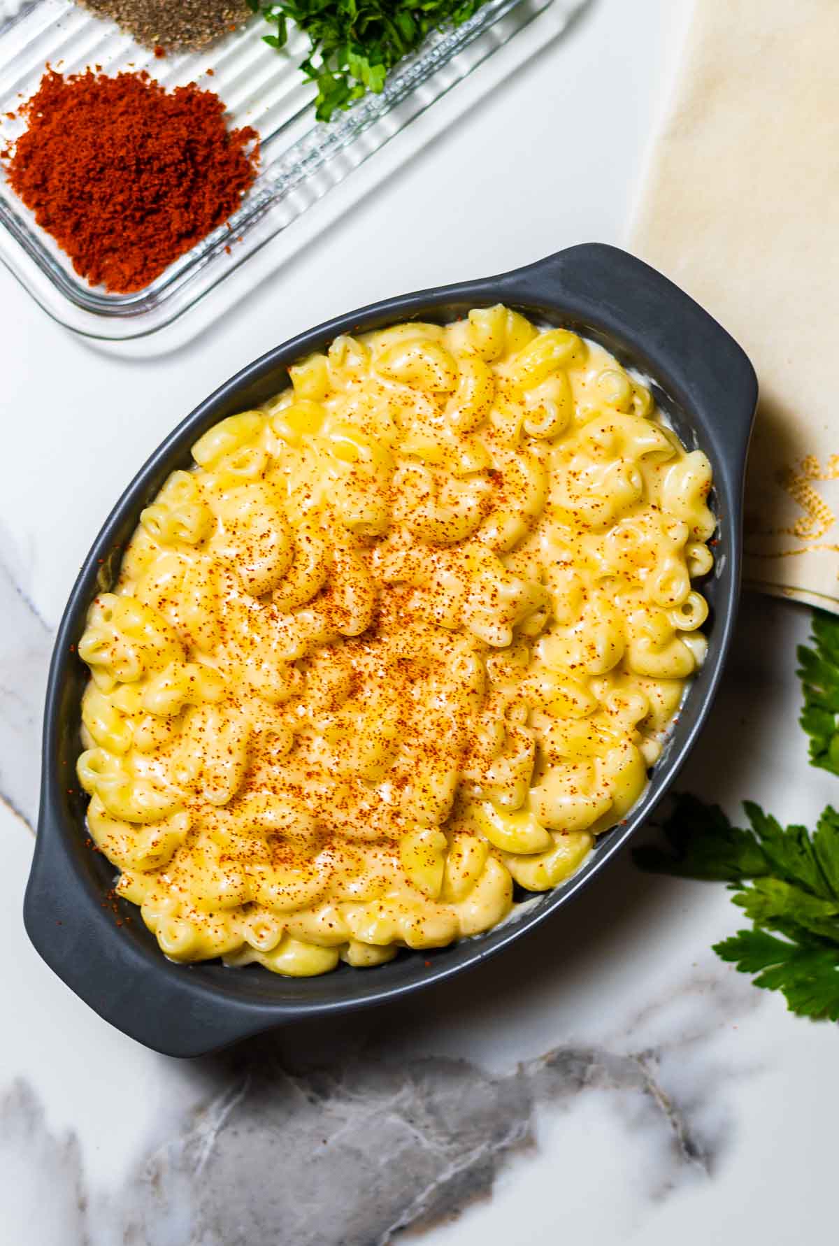 Gouda mac and cheese in a large cast iron dish on a white surface.