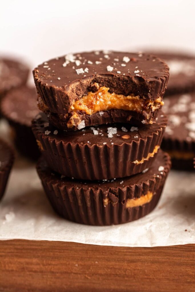 Sugar free peanut butter cups stack with one biten into.