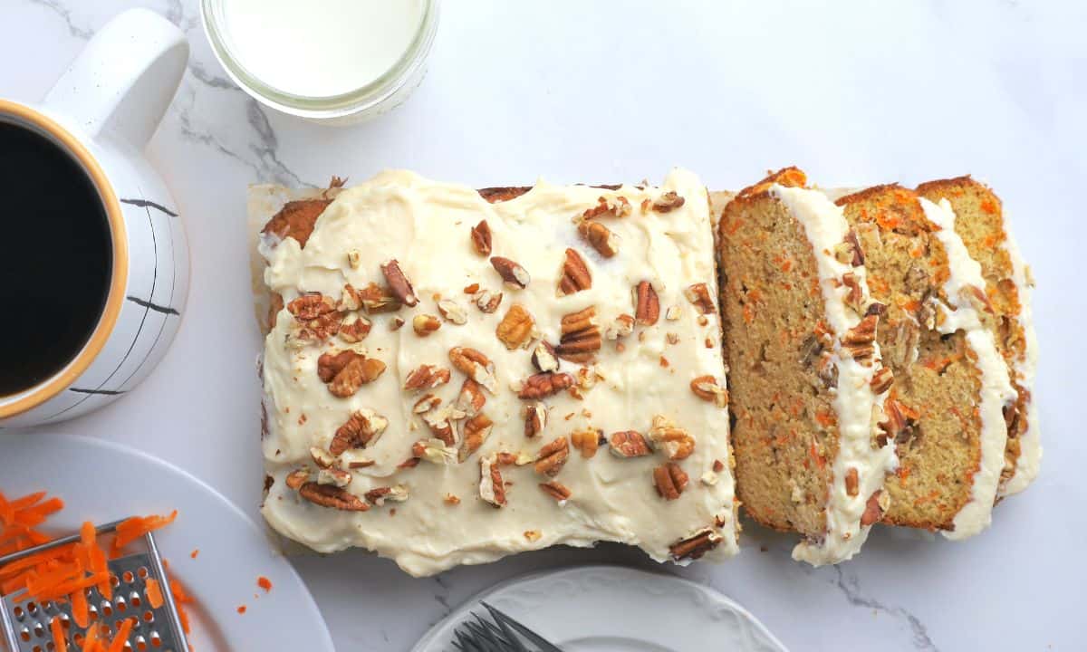 Sugar free carrot loaf flatlay. Slices falling on the table next to the loaf.