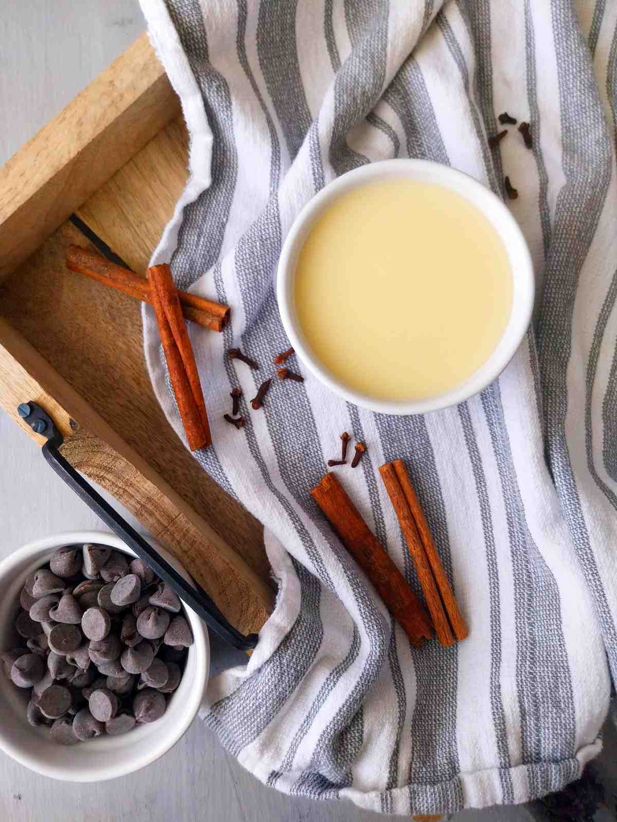 Sweetened condensed milk with chocolate chips and cinnamon sticks.