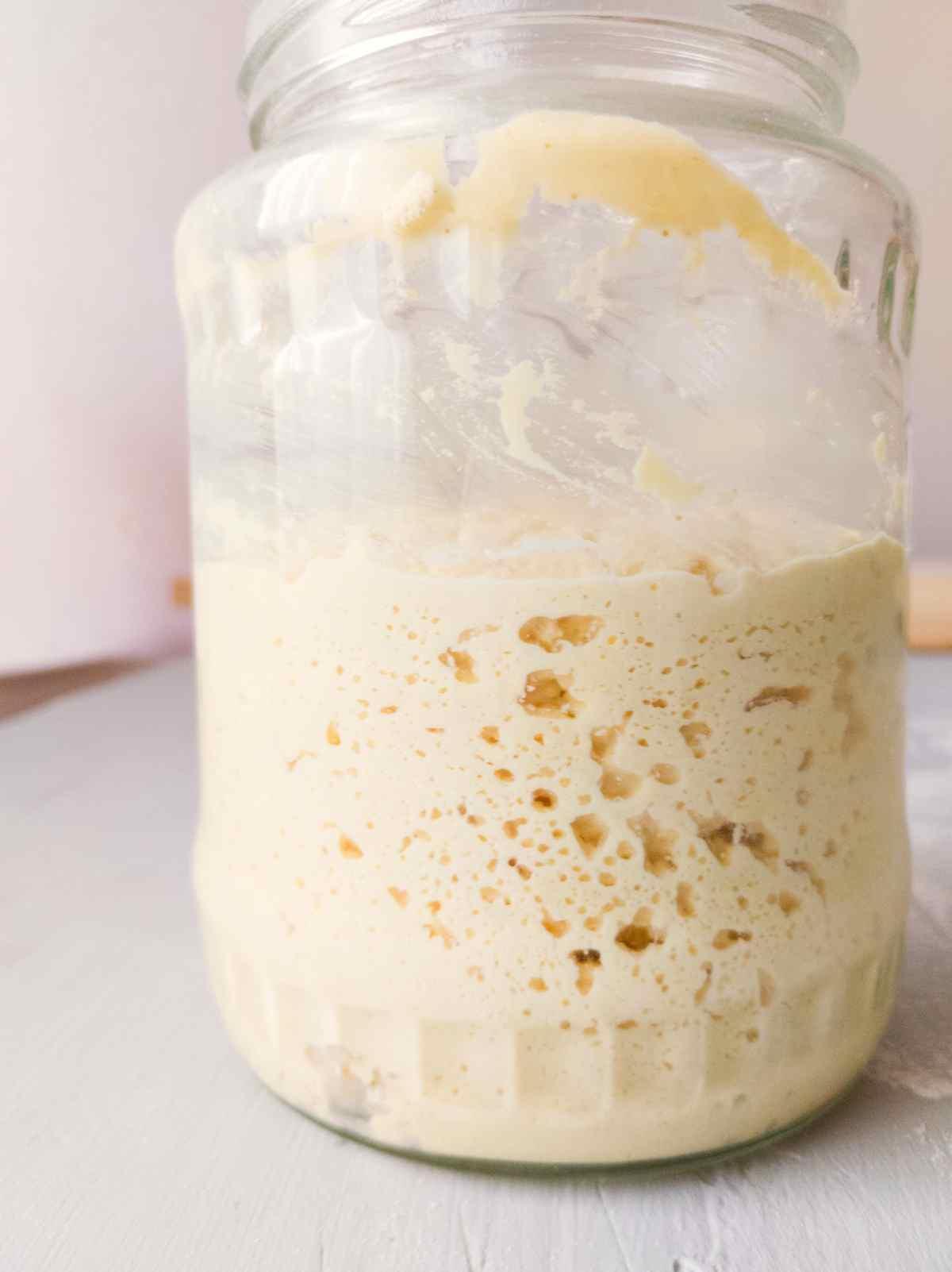 A glass jar with a millet sourdough starter in it.