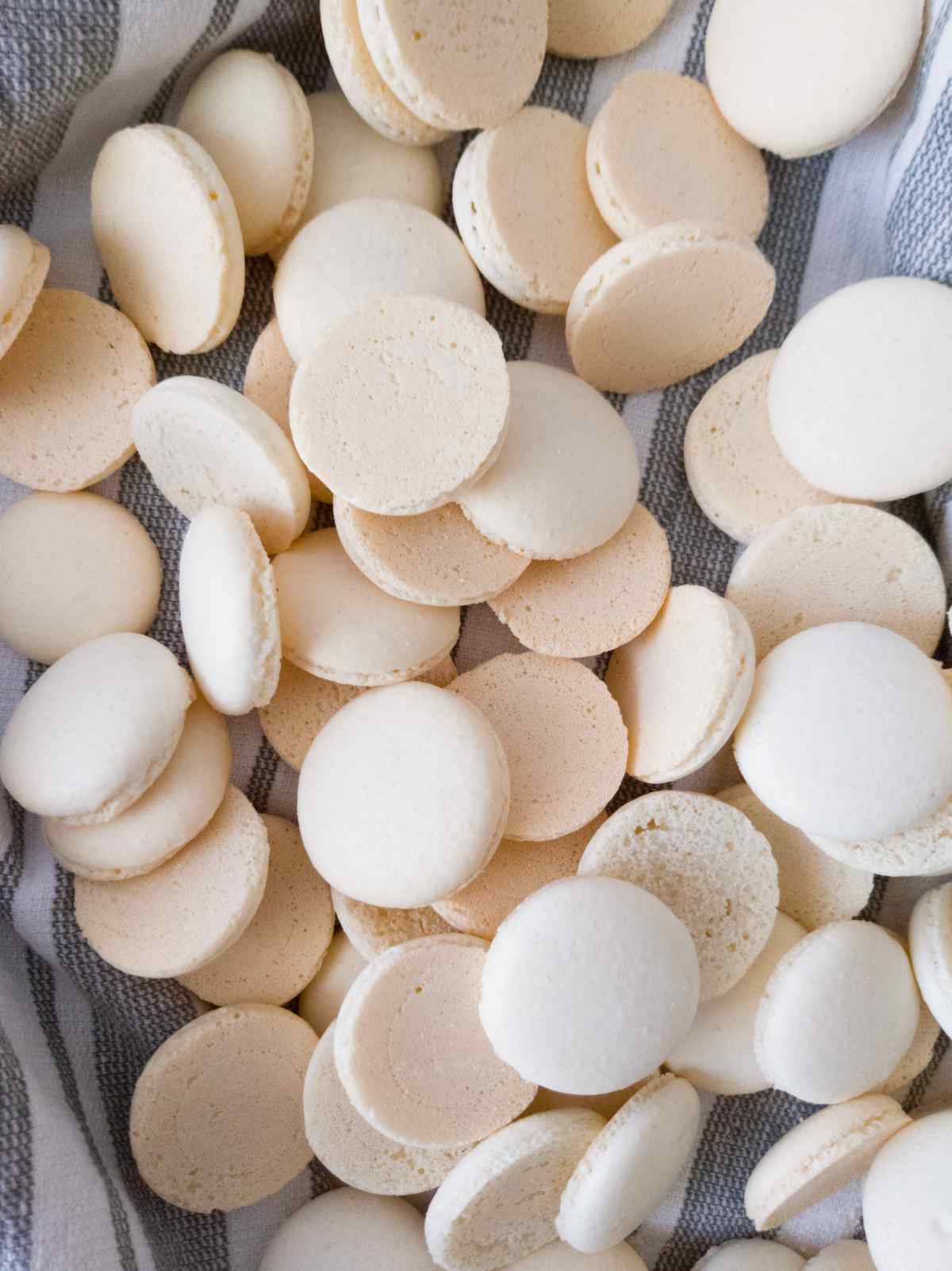 Macaron shells on a tea towel.