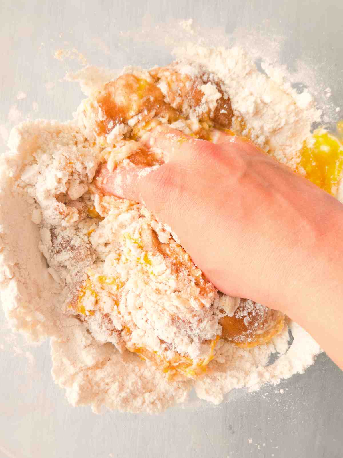 Mixing the dough by hand in a large glass bowl.