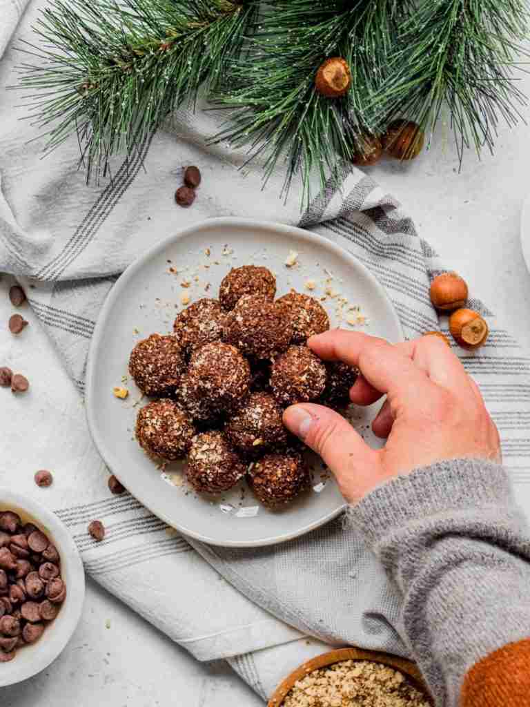 The hazelnut balls on a celebratory table and a hand reaching for them.