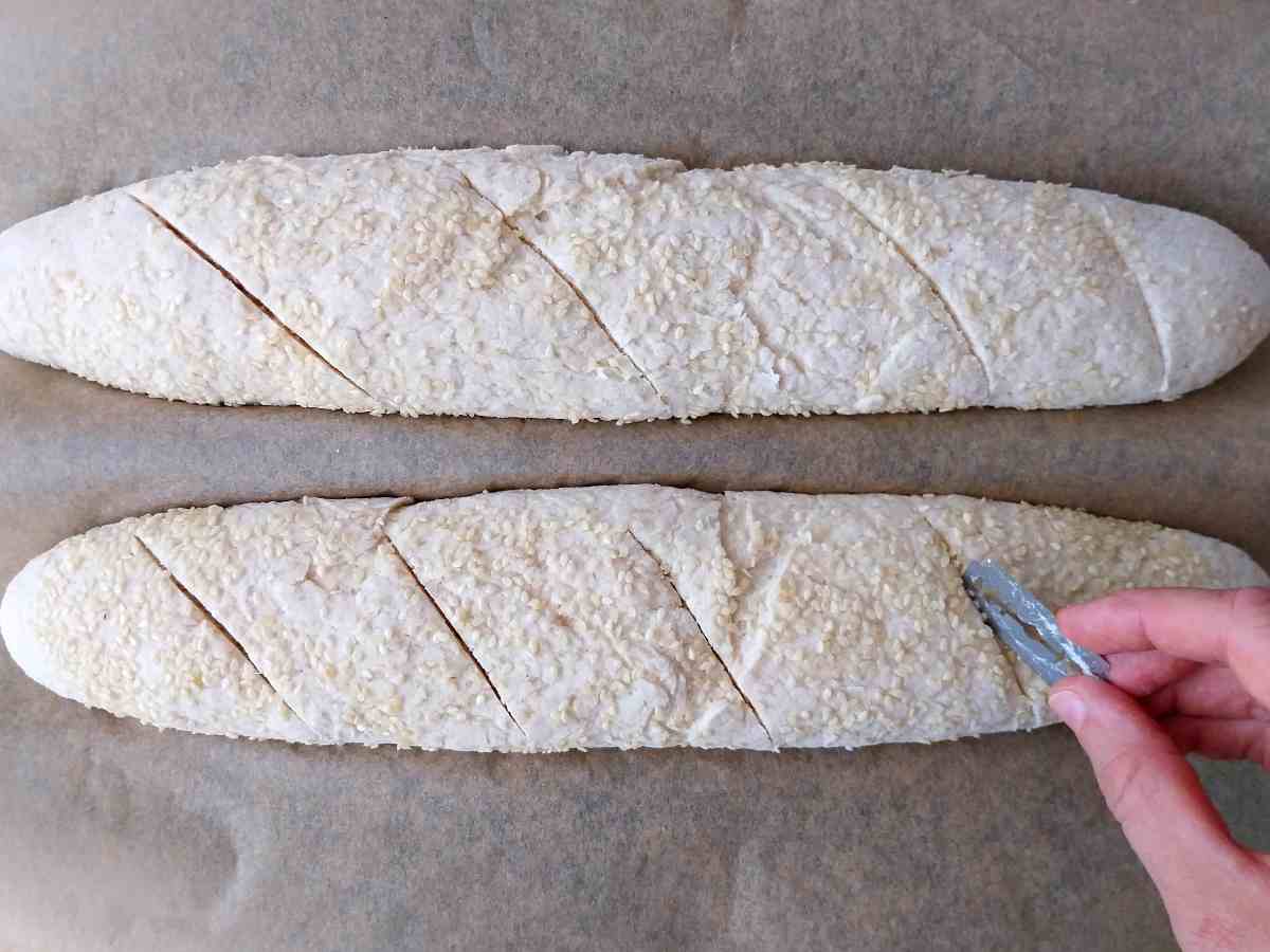 Scoring the baguettes with a sharp razor.