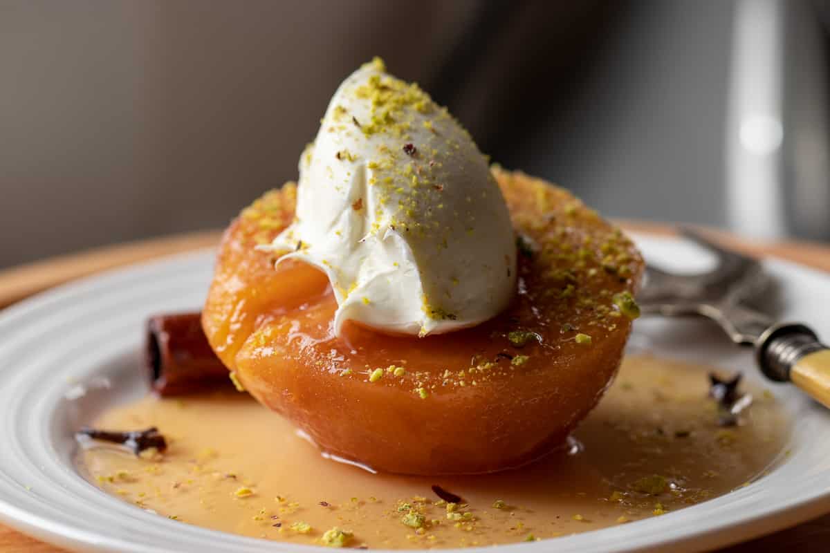 The dessert with a gallop of cream cheese on top on a white plate.