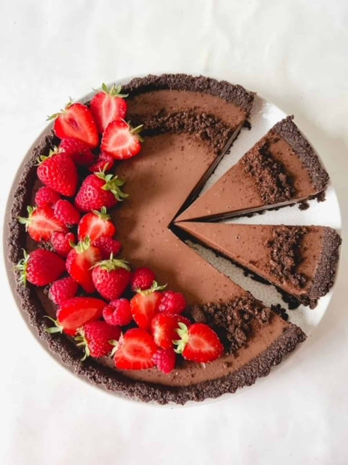 Oreo tart with strawberries on top with two slices cut out.