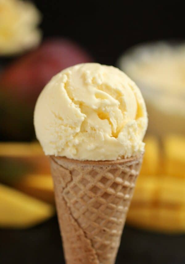 Mango ice cream in an ice cream cone.