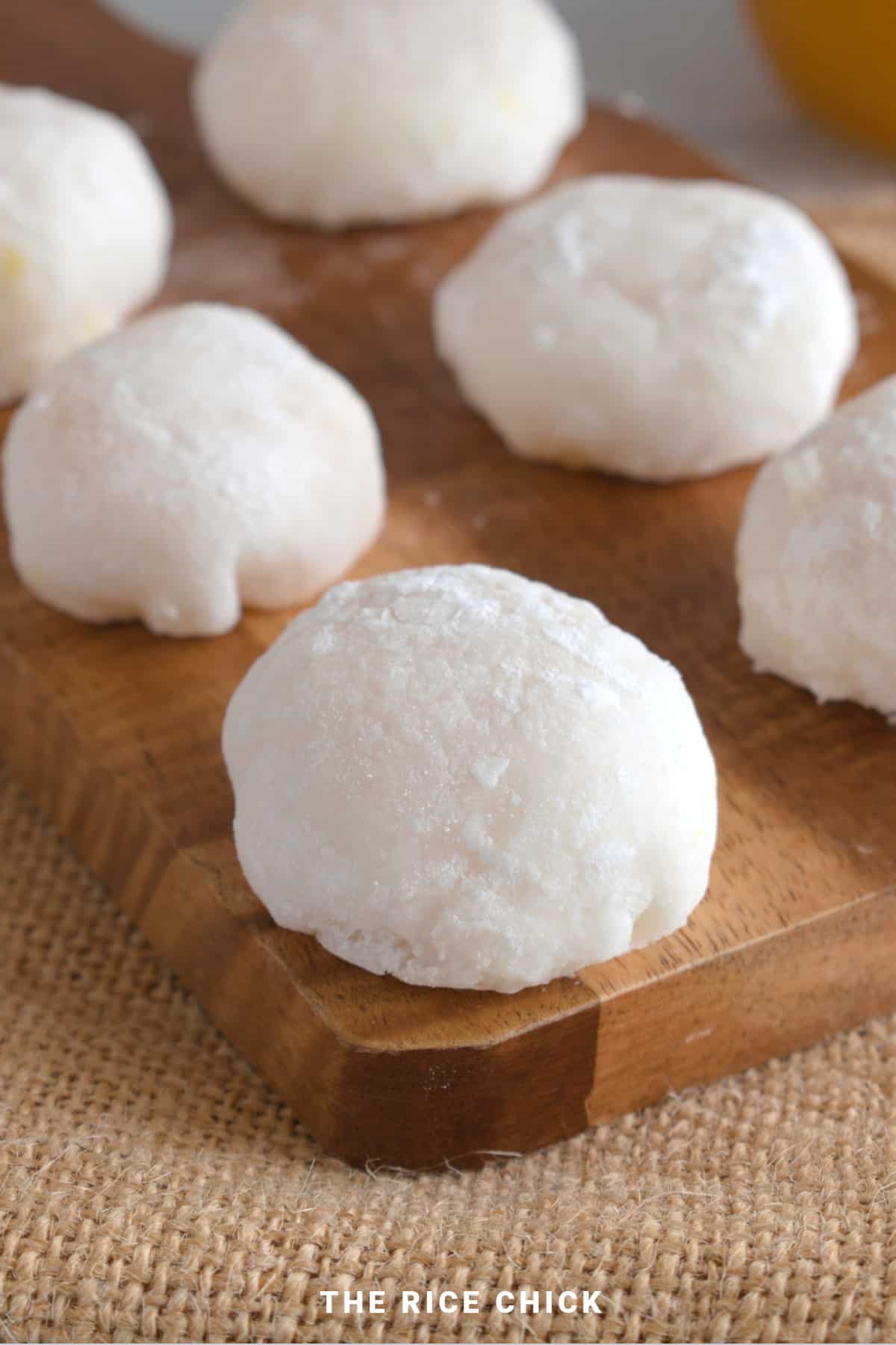 White mango mochi on a wooden board.