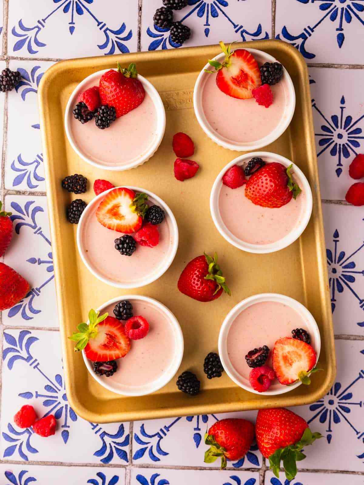 Strawberry panna cotta on a tray on a table with a pattern.