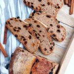 Gluten-free sourdough sliced on a wooden board and a kitchen towel.