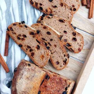 Gluten-free sourdough sliced on a wooden board and a kitchen towel.