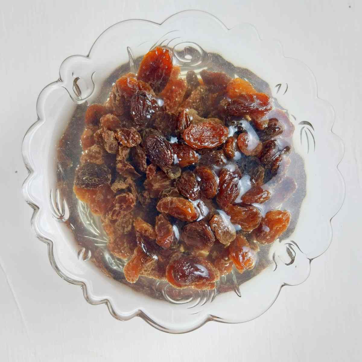 Soaking raisins in a little bowl with water.