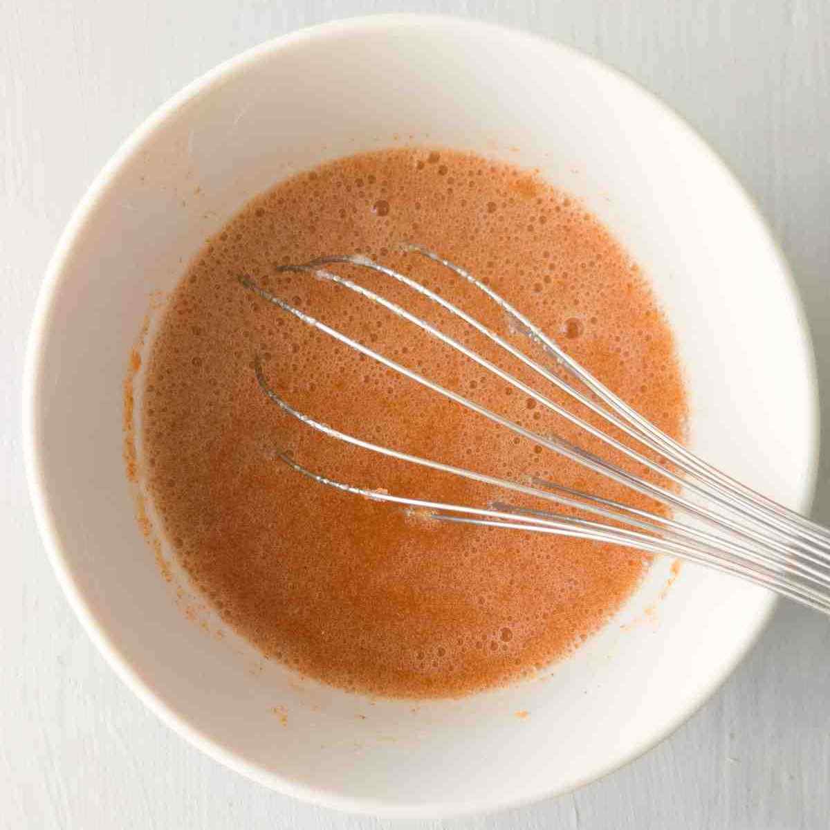 A bowl with psyllium gel and a whisk on a white table.