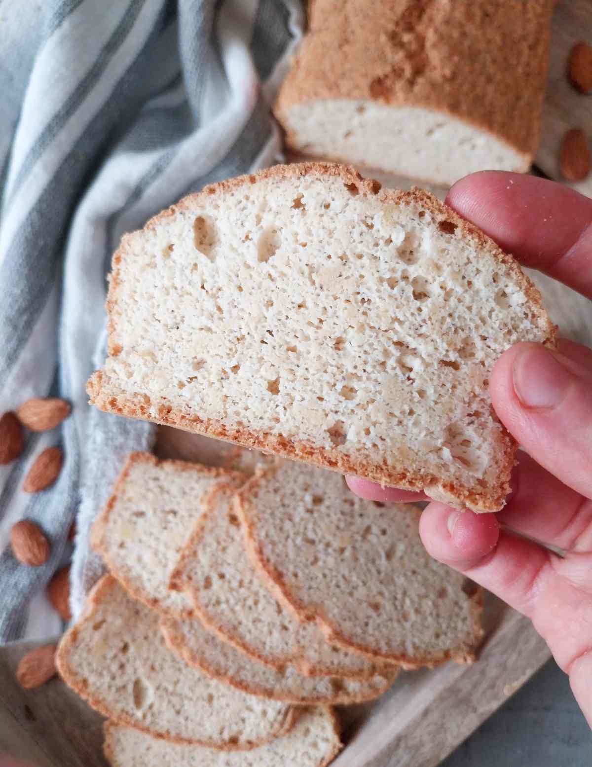 A slice of low-carb gluten-free bread up close with the rest of the bread in the background.