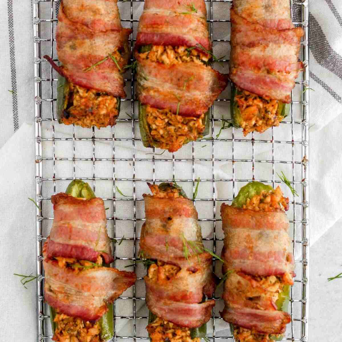 Buffalo chicken poppers on a wire rack on a white kitchen towel.