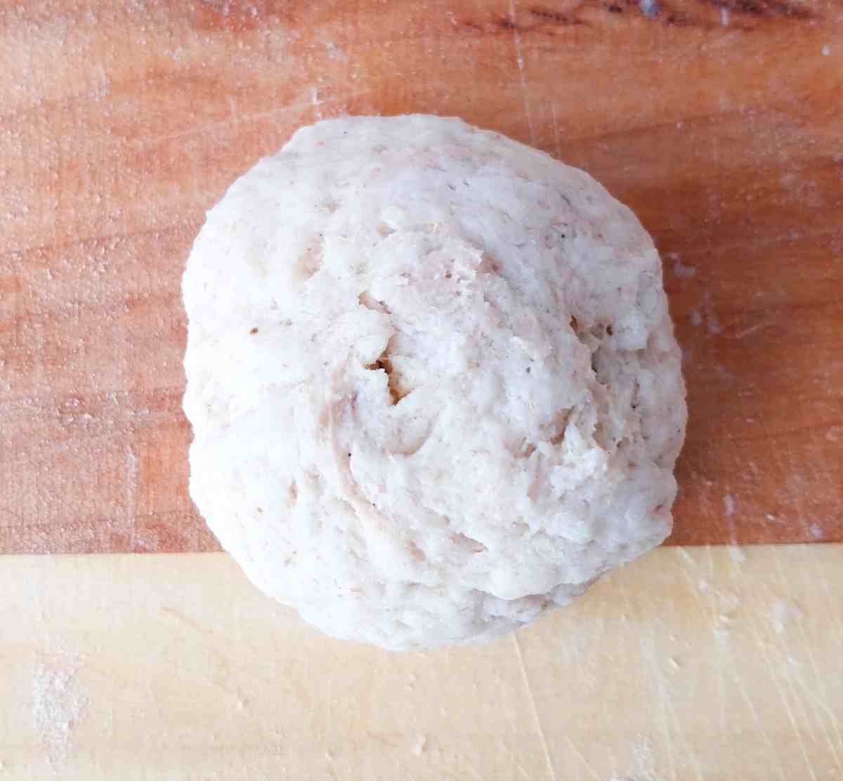 The dough ball on a wooden surface.