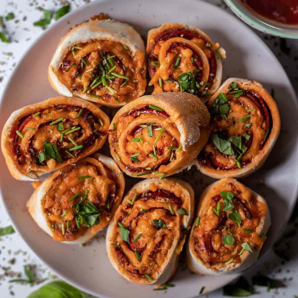 Gluten-free pizza rolls on a white plate.