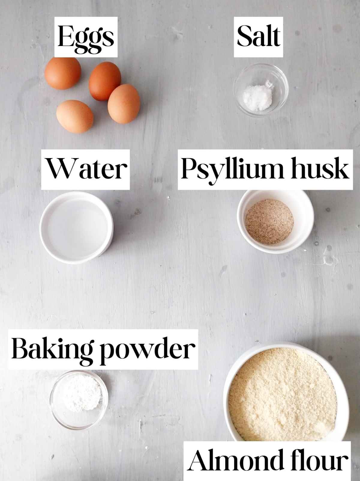 Ingredients in small bowls on a gray surface.