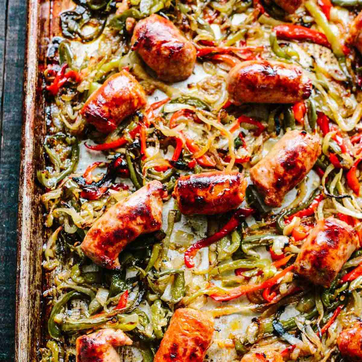 A tray with veggies and sausage slices baked.