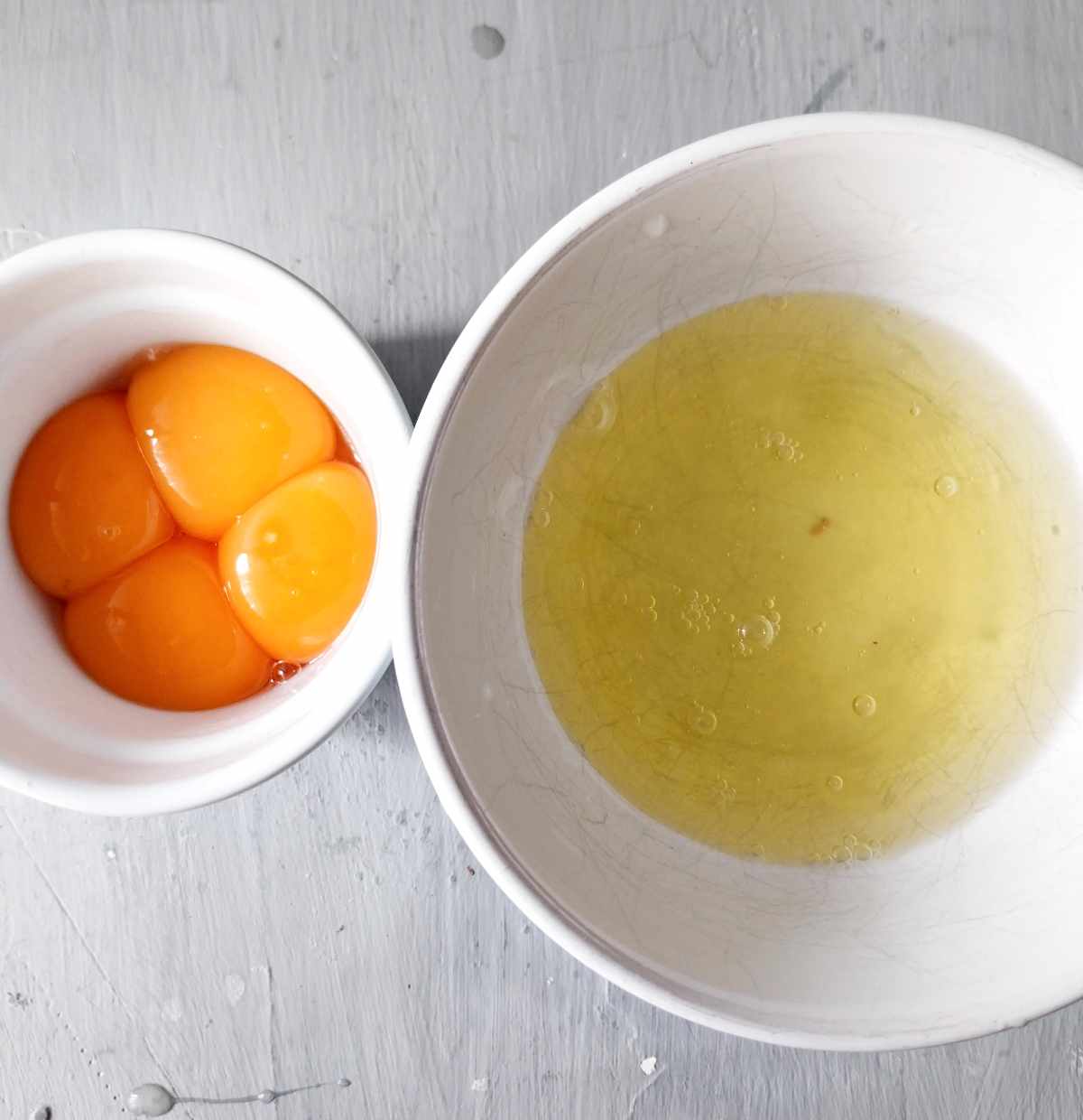 Egg yolks and egg whites in separate bowls.