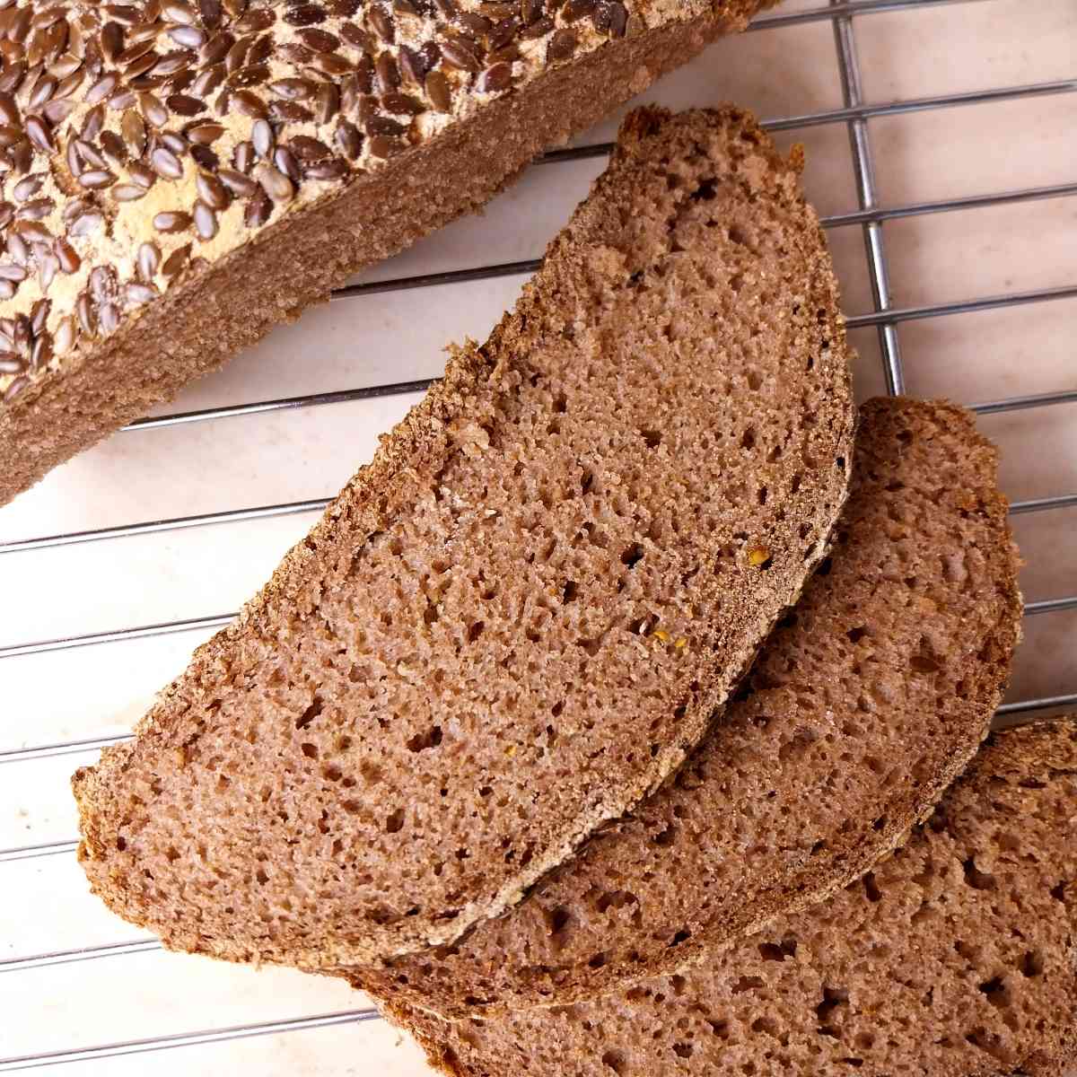 Gluten-free teff bread sliced on a cooling rack.