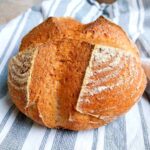 Brown rice sourdough loaf on a kitchen towel.