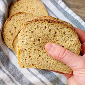 A slice of millet sourdough in a hand up close.