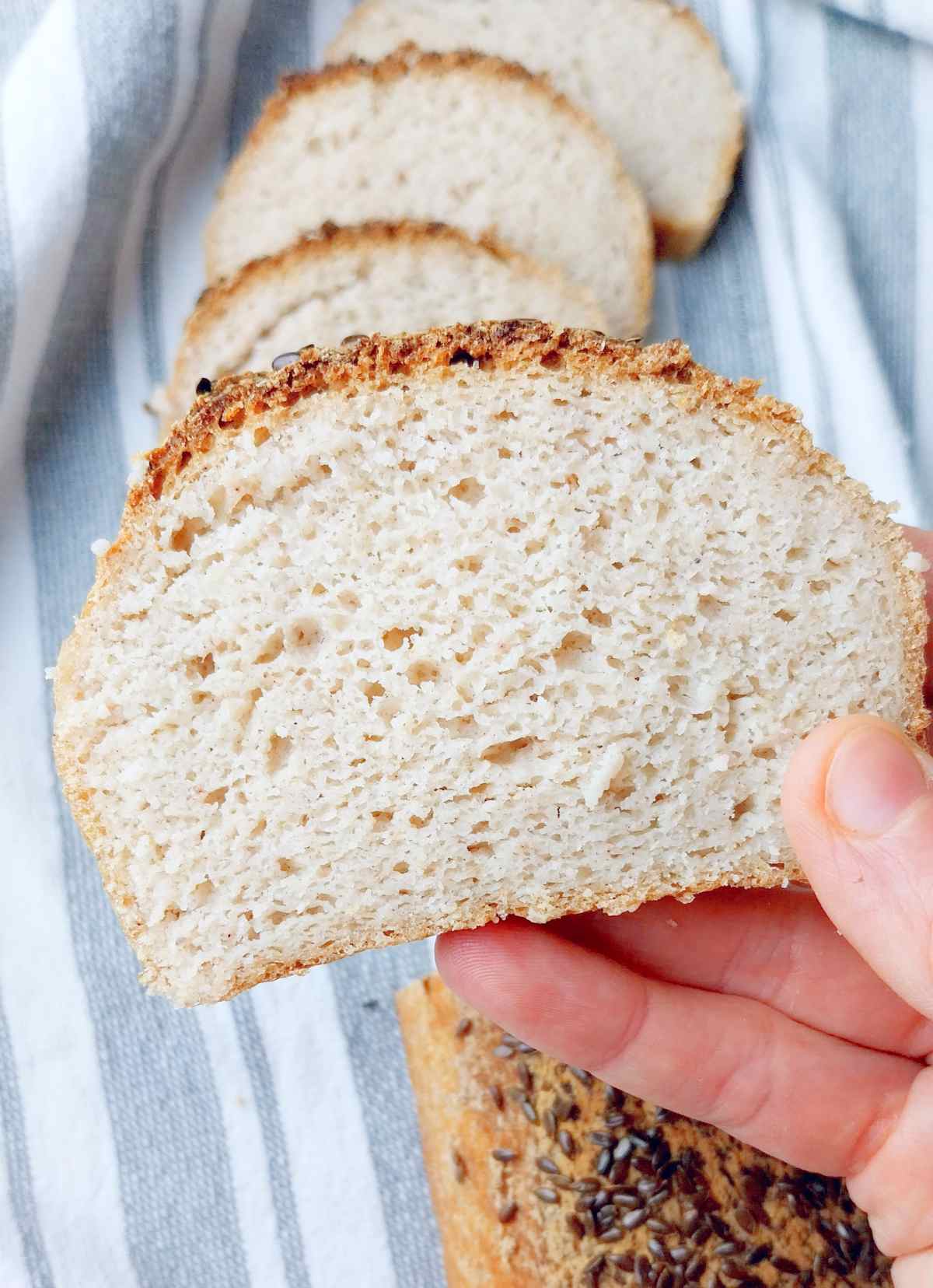 A slice of sorghum sourdough in a hand. 