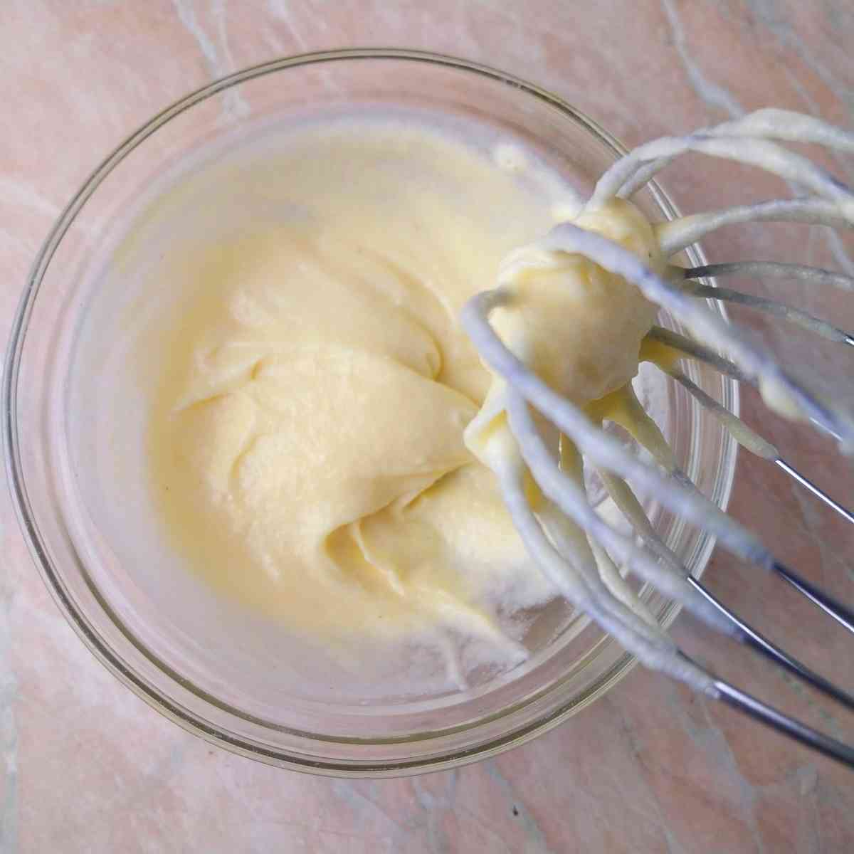 Flour mixture in a glass bowl with a whisk.