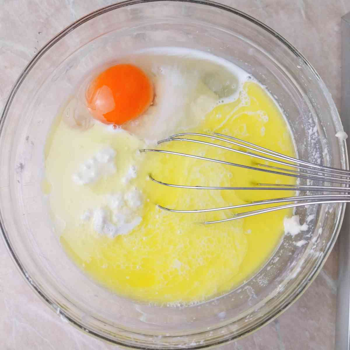 Wet ingredients in a bowl with a whisk.