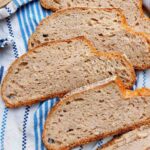 Sliced buckwheat sourdough bread on a kitchen towel.