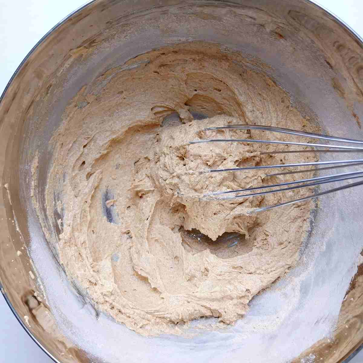 The cake batter mixed with a whisk.