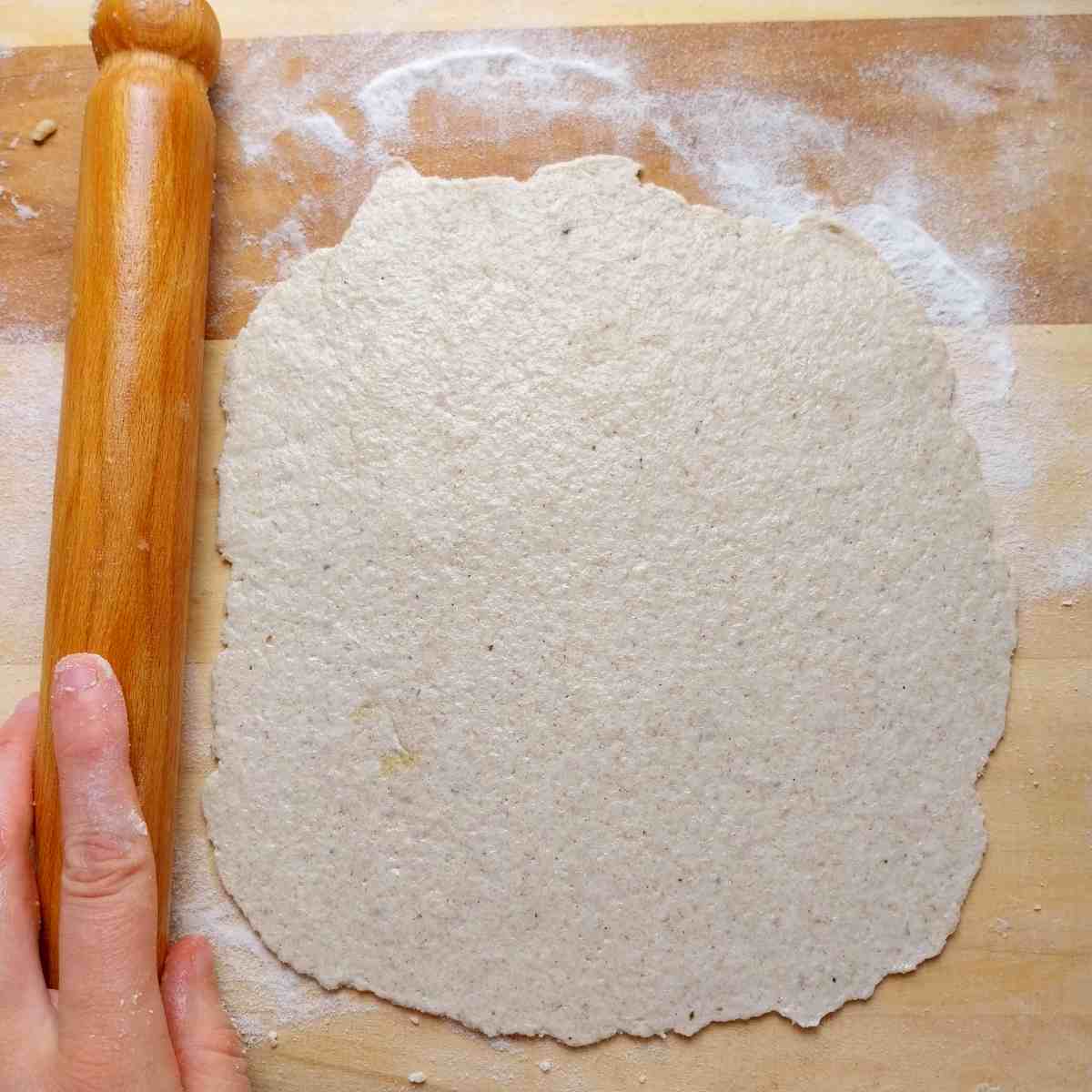 Rolled out flatbread on a wooden surface.