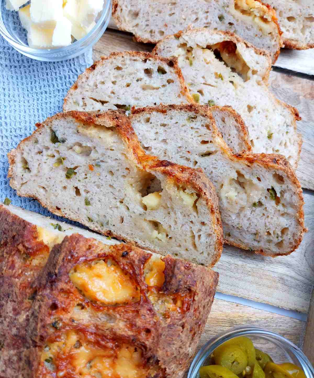 Gluten-free cheddar jalapeno sourdough sliced on a wooden surface.