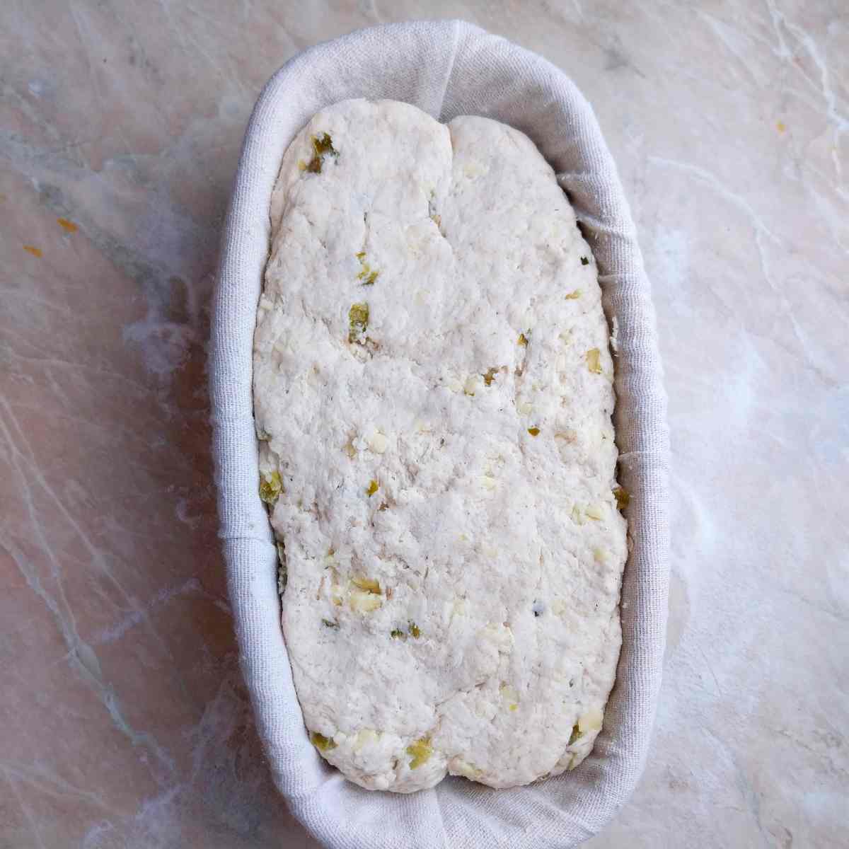 The loaf in a banneton basket.