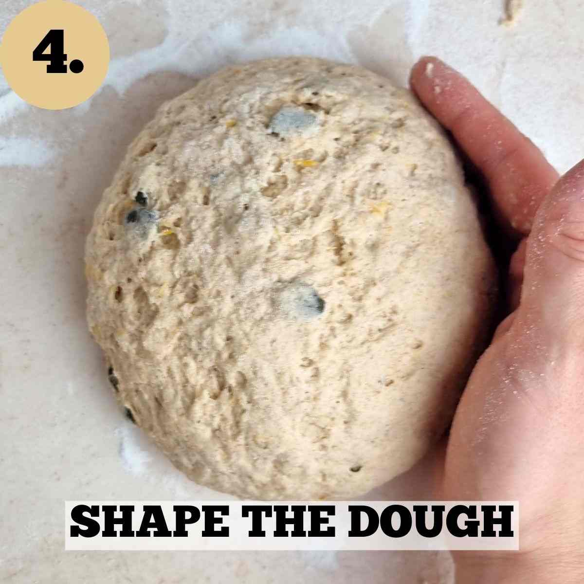 The dough shaped into a ball on a kitchen surface.