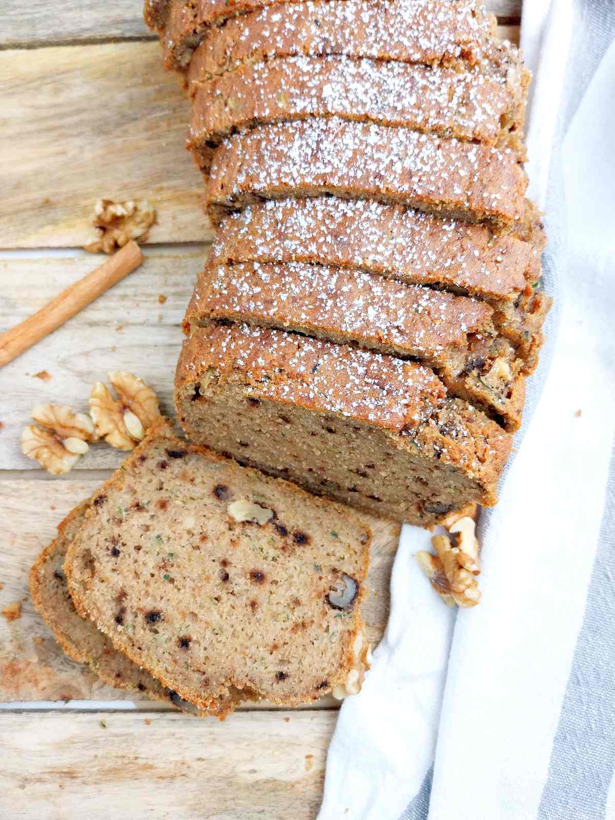 Sliced buckwheat zucchini bread on a wooden surface.
