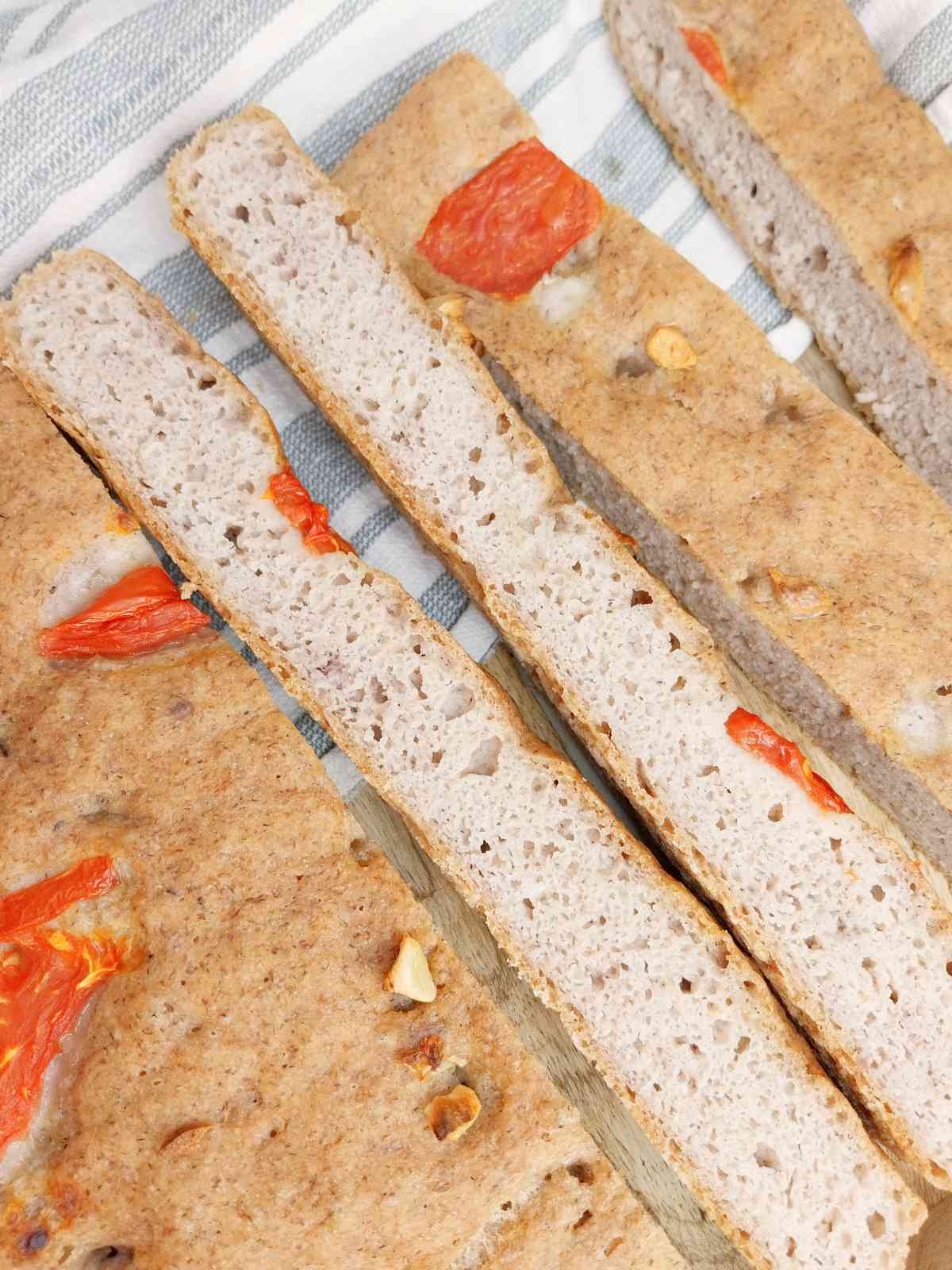 Slices of buckwheat focaccia on a kitchen towel.