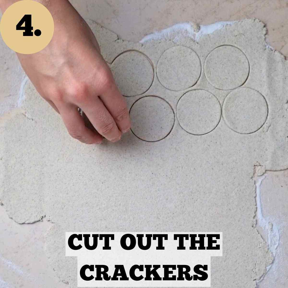 Cutting out round cracker shapes with a cookie cutter on a floured surface.