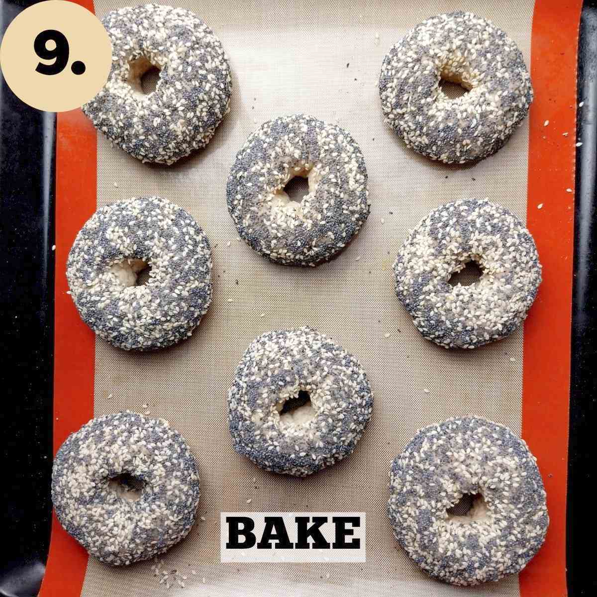 Topped bagels on a baking sheet before baking.