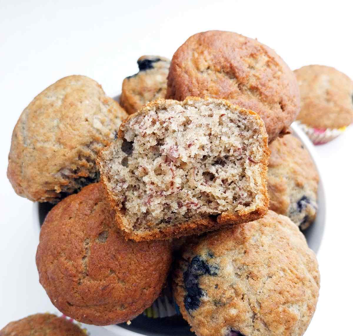 Buckwheat banana muffins in a white bowl against a white surface.