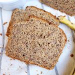 A slice of gluten-free banana nut bread on a kitchen towel.