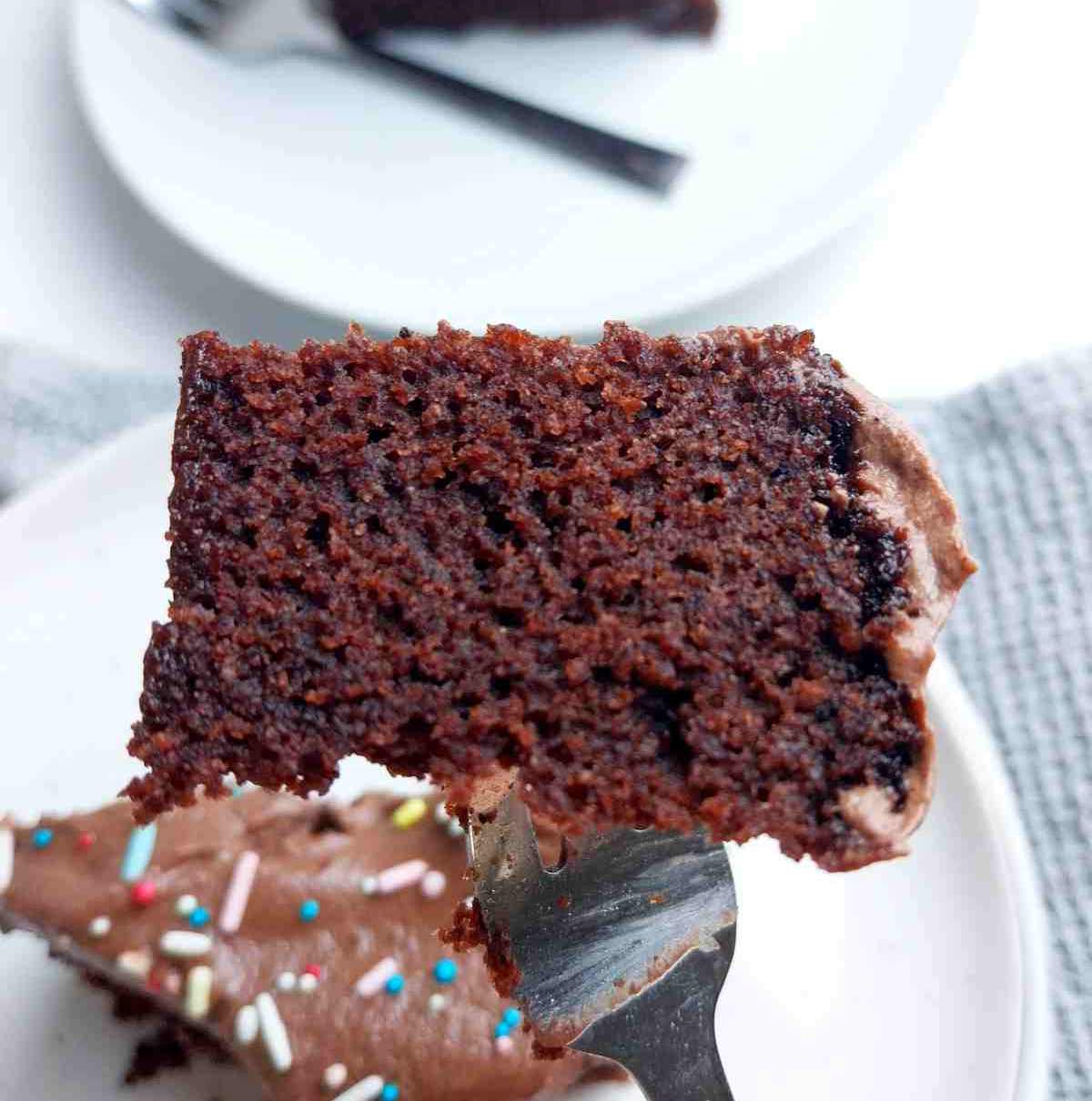 A slice of buckwheat cake on a fork with another slice on a plate in the background.