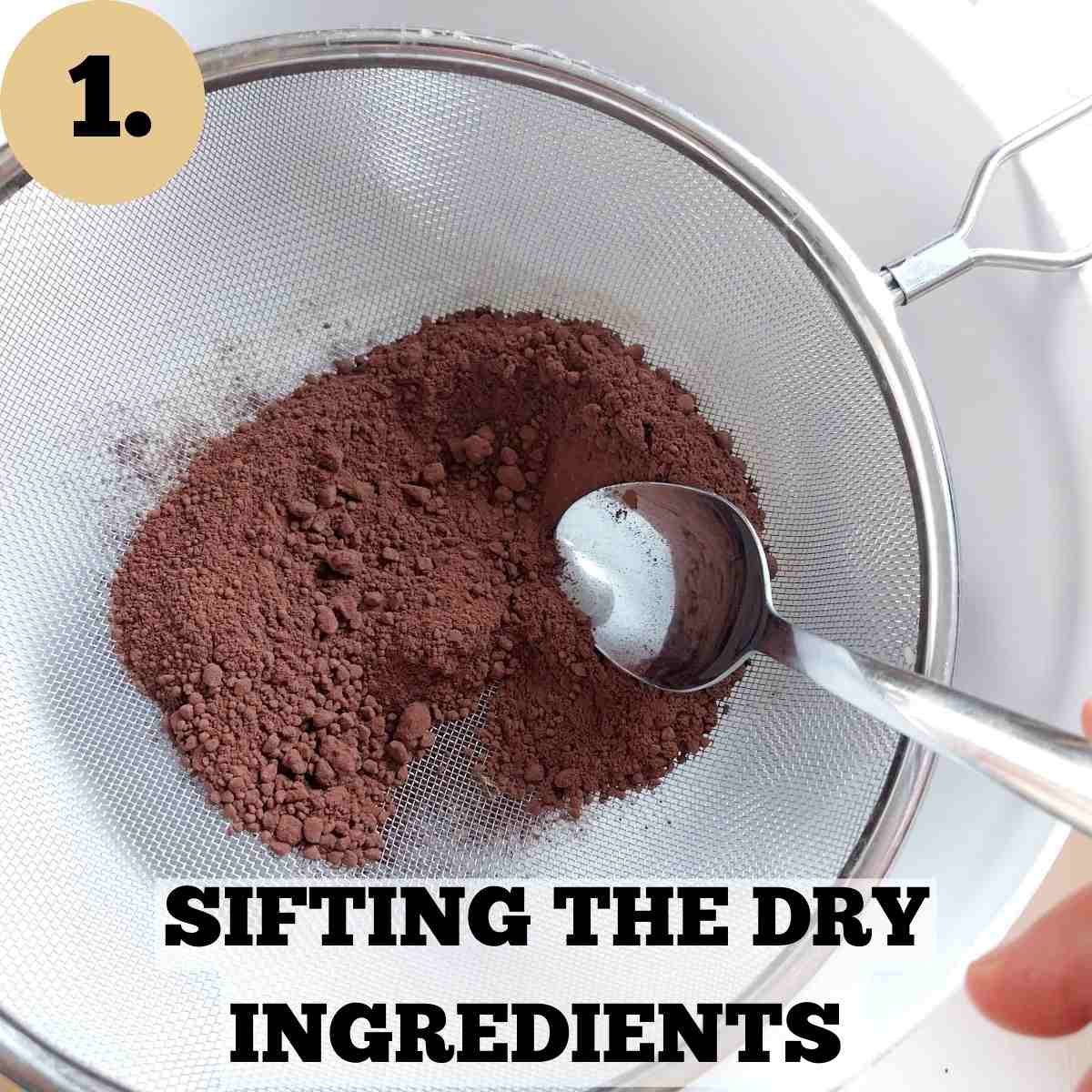 A sieve with cocoa powder and a spoon in it with the mixing bowl in the background.