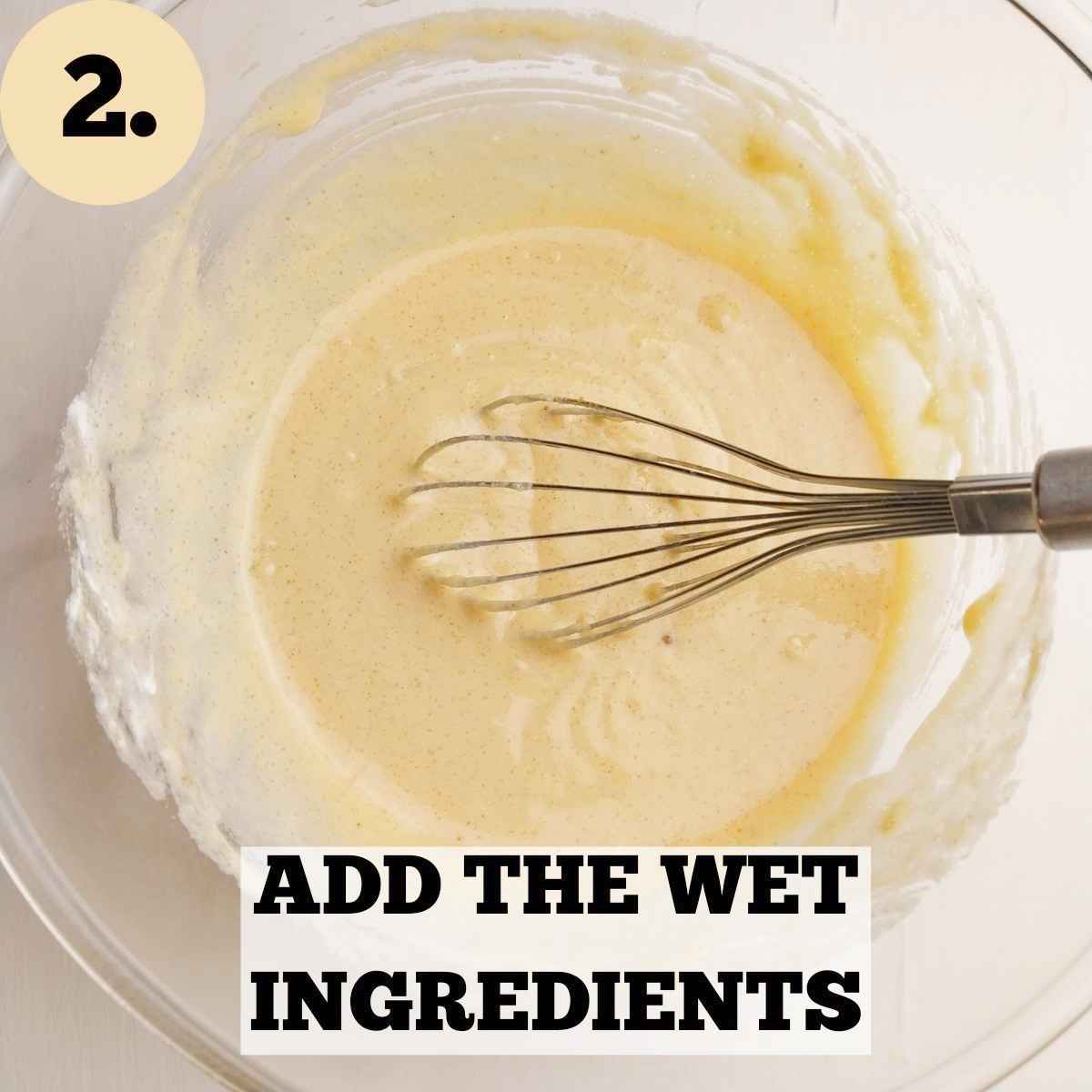 Wet ingredients mixed in a glass mixing bowl with a whisk in it.